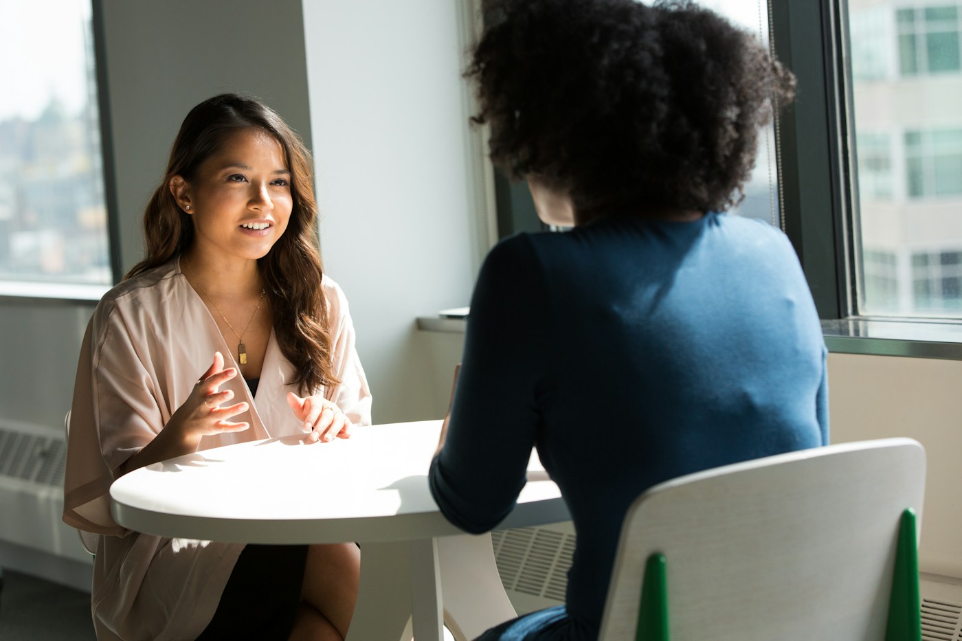 Two people sharing a conversation in a bright, calm setting